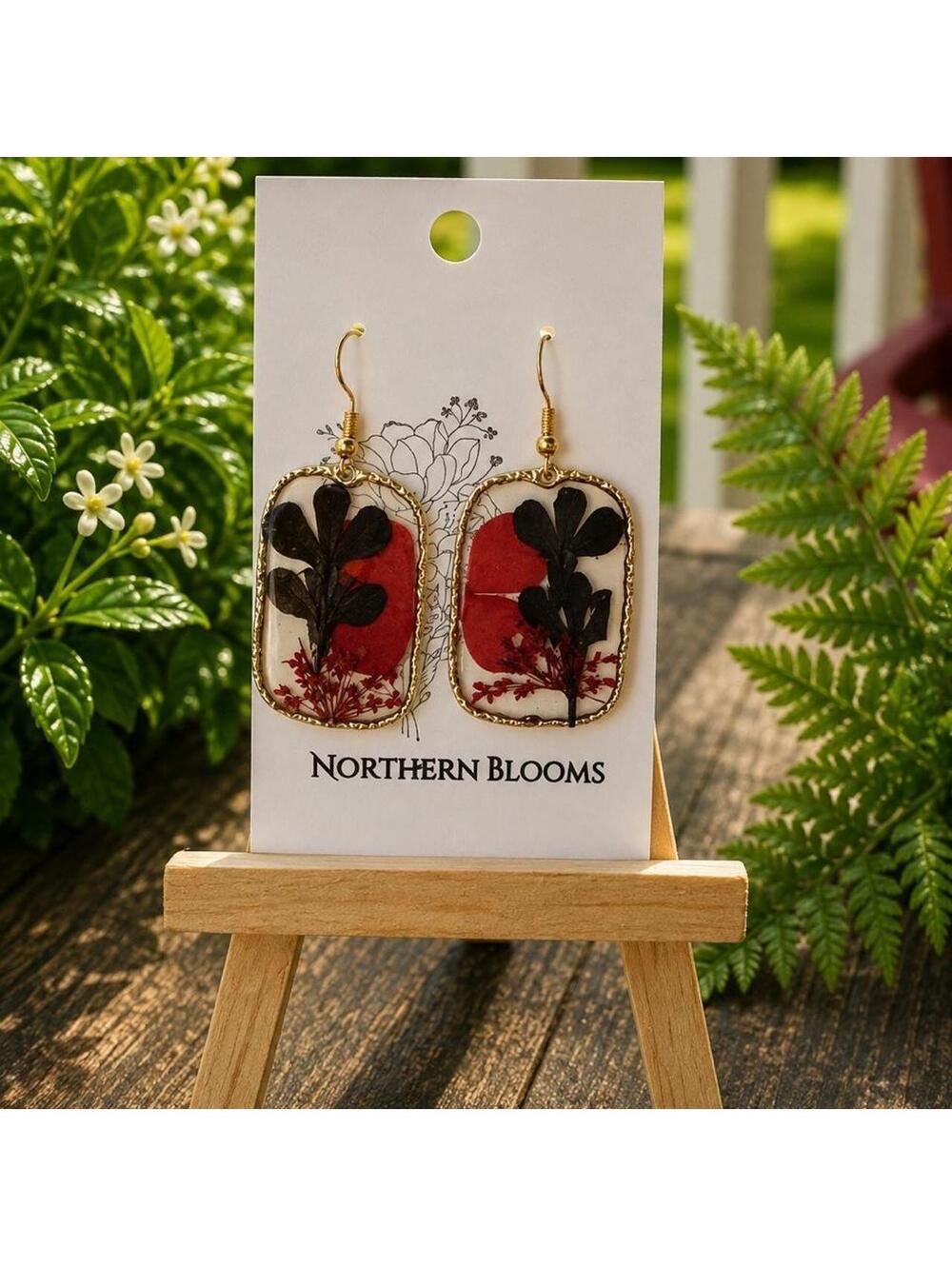 Pressed black leaf with red floral accents in rectangular setting
